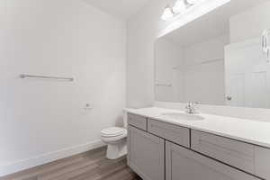 Bathroom featuring vanity, toilet, wood-type flooring, and walk in shower