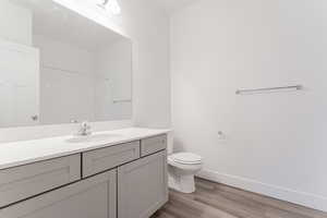 Bathroom with vanity, toilet, and hardwood / wood-style flooring