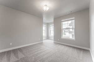 Spare room featuring a textured ceiling and light colored carpet