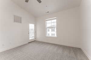 Unfurnished room featuring lofted ceiling, carpet floors, and ceiling fan