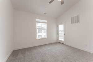 Spare room featuring ceiling fan, carpet, and lofted ceiling