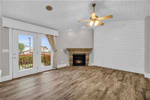 Unfurnished living room featuring vaulted ceiling, hardwood / wood-style floors, and ceiling fan