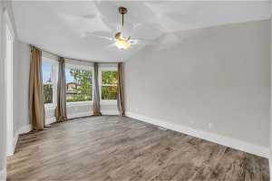 Unfurnished room with light hardwood / wood-style floors, ceiling fan, and vaulted ceiling