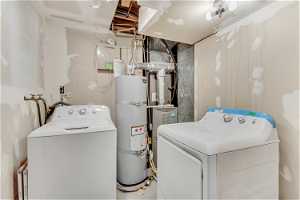 Washroom featuring washer / dryer and strapped water heater