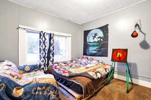 Carpeted bedroom featuring a textured ceiling