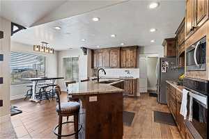 Kitchen with plenty of natural light, appliances with stainless steel finishes, dark hardwood / wood-style floors, and sink