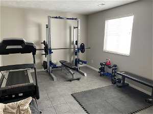 Workout area with a textured ceiling and tile floors