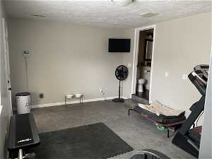Workout room with tile flooring and a textured ceiling