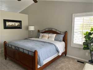 Bedroom with lofted ceiling, ceiling fan, crown molding, and carpet floors