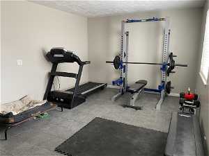 Exercise room featuring tile flooring and a textured ceiling