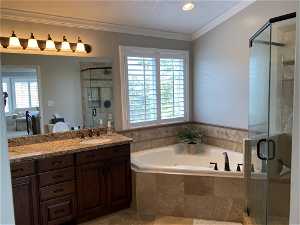 Bathroom with plus walk in shower, a wealth of natural light, vanity, and tile flooring