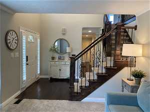 Entryway with crown molding and dark hardwood / wood-style floors