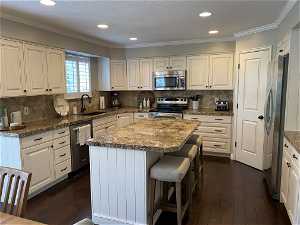 Kitchen with dark hardwood / wood-style flooring, sink, appliances with stainless steel finishes, and backsplash