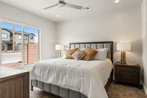 Carpeted bedroom featuring ceiling fan