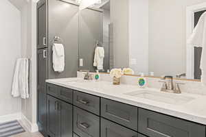 Bathroom with double vanity and wood-type flooring