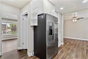 Kitchen featuring white cabinets, dark hardwood / wood-style floors, stainless steel refrigerator with ice dispenser, and ceiling fan