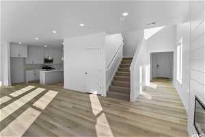 Staircase featuring sink and light hardwood / wood-style floors