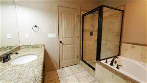 PrimaryBathroom featuring tile floors, shower with separate bathtub, and large vanity