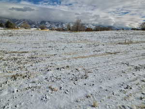 Yard covered in snow featuring a mountain view