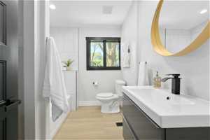Bathroom with sink, hardwood / wood-style floors, and toilet