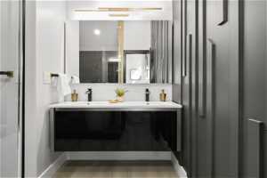 Bathroom with dual sinks, wood-type flooring, and large vanity
