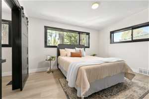 second master bedroom with light hardwood / wood-style floors