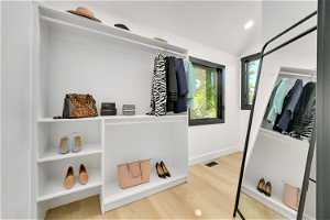 Walk in closet featuring vaulted ceiling and light hardwood / wood-style floors