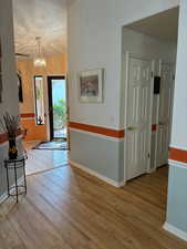 Foyer entrance featuring wood-type flooring, a chandelier, and a textured ceiling