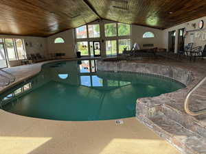 View of indoor pool with a hot tub