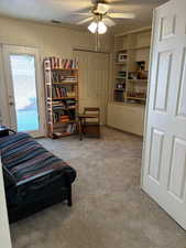 Bedroom featuring light colored carpet, a closet, ceiling fan, and a textured ceiling