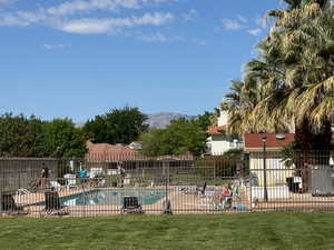 View of swimming pool with a mountain view and a lawn