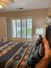 Bedroom with a textured ceiling and ceiling fan