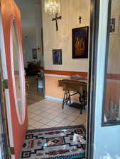 Entryway with tile flooring and an inviting chandelier