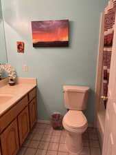 Full bathroom featuring shower / bath combo, vanity, toilet, and tile flooring