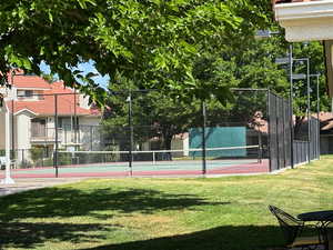 View of sport court with a yard