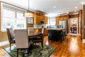Dining area with sink, crown molding, and hardwood / wood-style floors