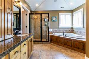 Bathroom with vanity, tile floors, and shower with separate bathtub