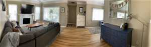 Living room with ornamental molding and hardwood / wood-style floors
