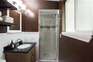 Bathroom with large vanity, an enclosed shower, and toilet