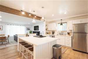 Kitchen with white cabinets, sink, appliances with stainless steel finishes, and light hardwood / wood-style flooring