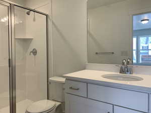 Bathroom with vanity, toilet, and a shower with shower door