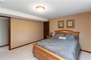 Bedroom with light carpet and a textured ceiling