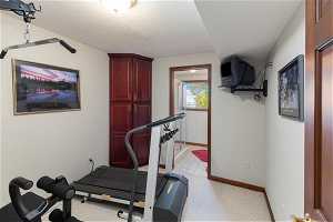 Workout room with light colored carpet and a textured ceiling