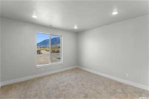 Carpeted empty room with a wealth of natural light and a mountain view
