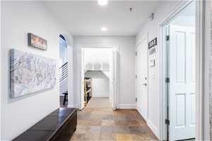 hallway from garage featuring mudroom closet