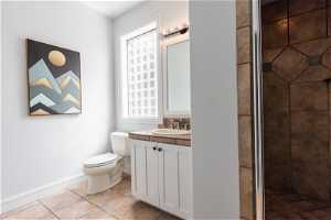 Bathroom 3 featuring a shower with door, toilet, tile floors, and vanity