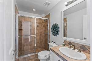 Bathroom 4 with an enclosed shower, tile floors, vanity, backsplash, and toilet
