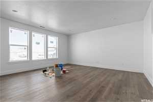 Unfurnished room with wood-type flooring and a textured ceiling