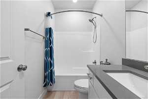 Full bathroom with shower / bath combo, toilet, vanity, and hardwood / wood-style flooring