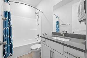 Full bathroom with shower / bath combo, wood-type flooring, toilet, and vanity with extensive cabinet space